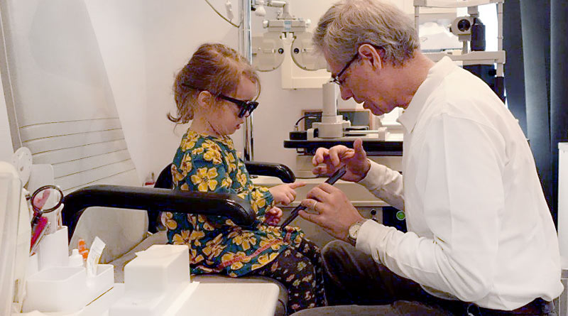 Dr. Martin Heidemann, Augenarzt im Team der Praxis Augenheilkunde am Europaplatzwährend Untersuchung eines Kindes